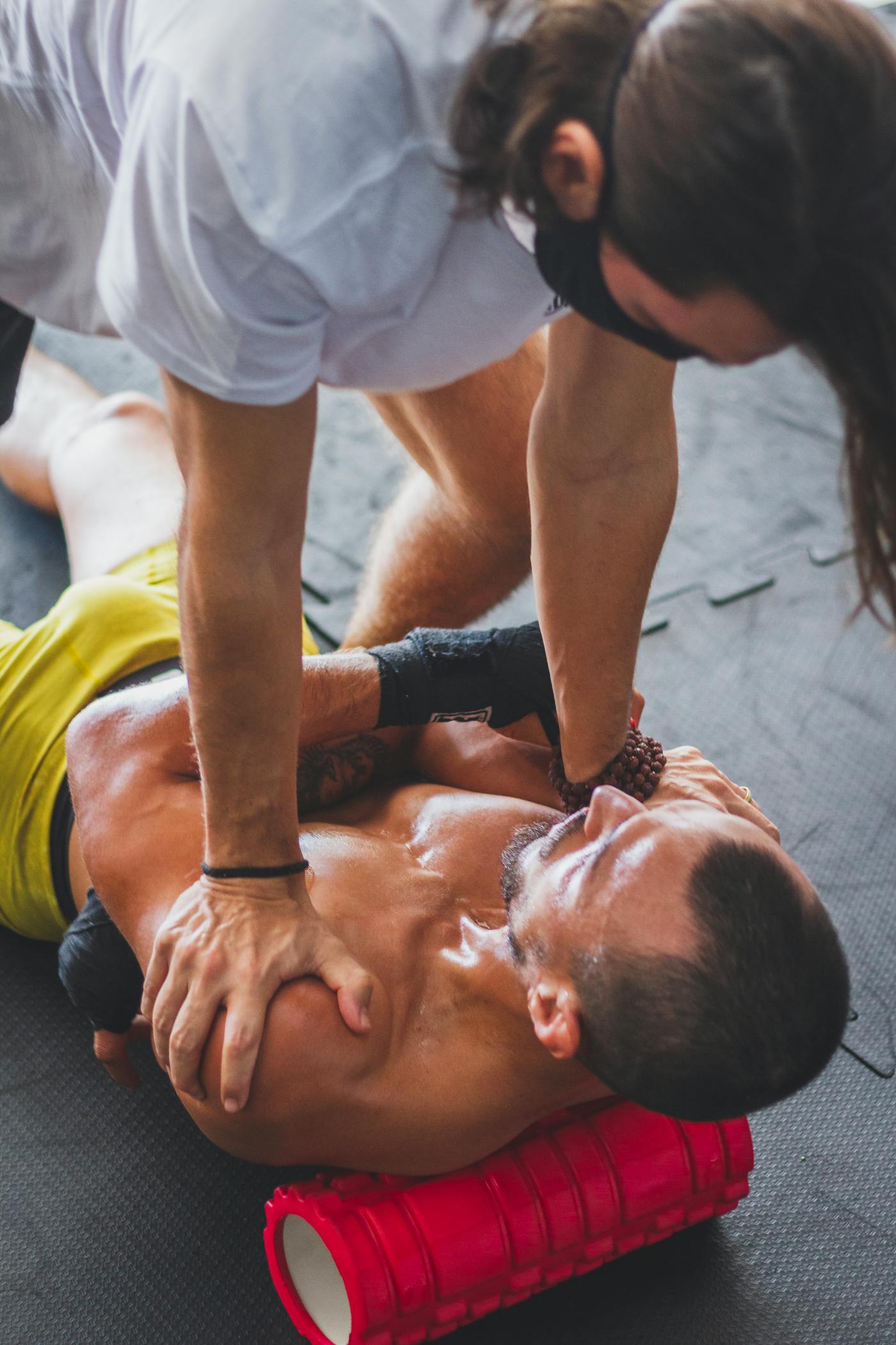 Athlete receiving sports recovery therapy with a foam roller